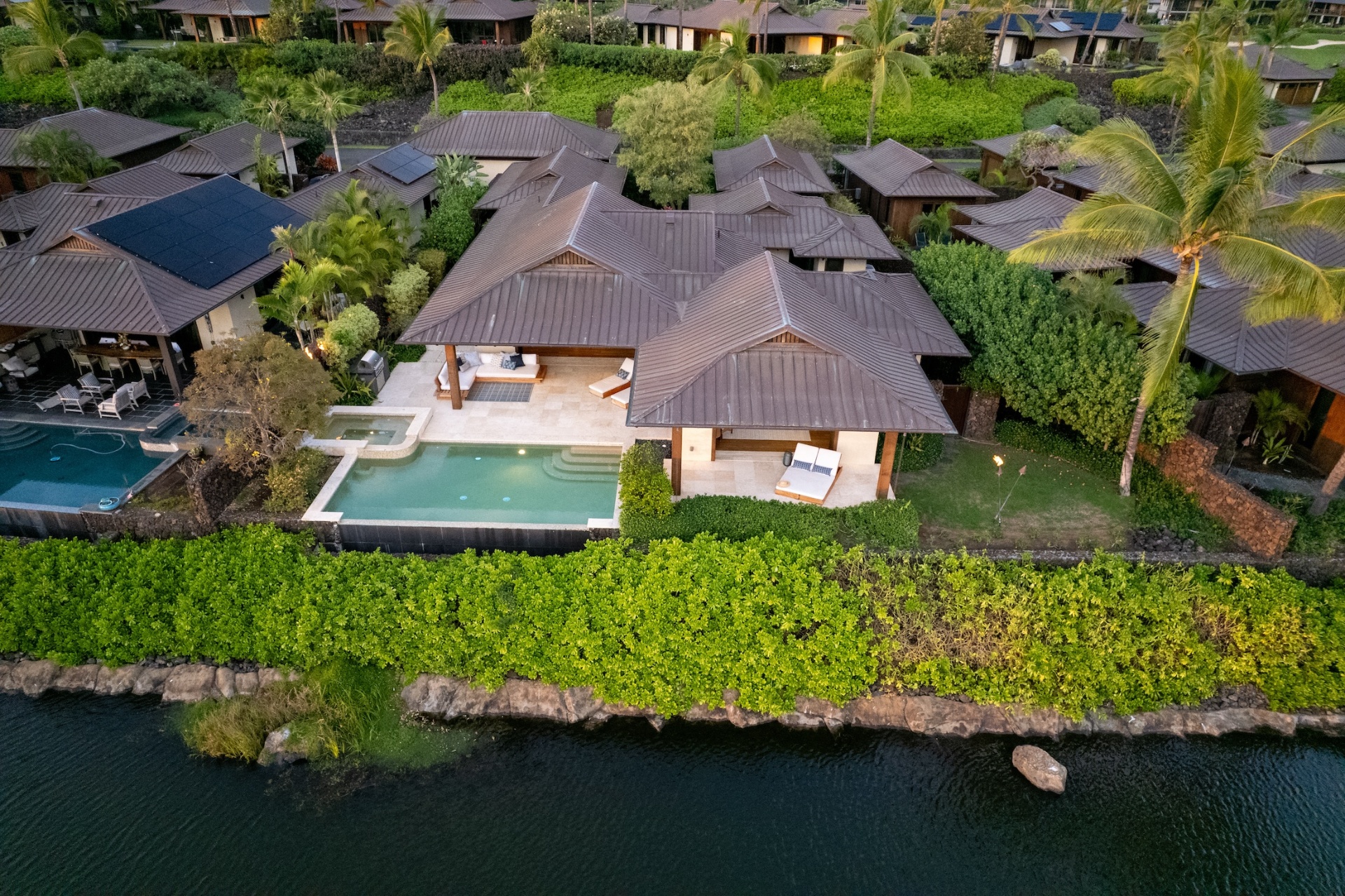Overhead aerial of residence rooftop, pool, and waterfront
