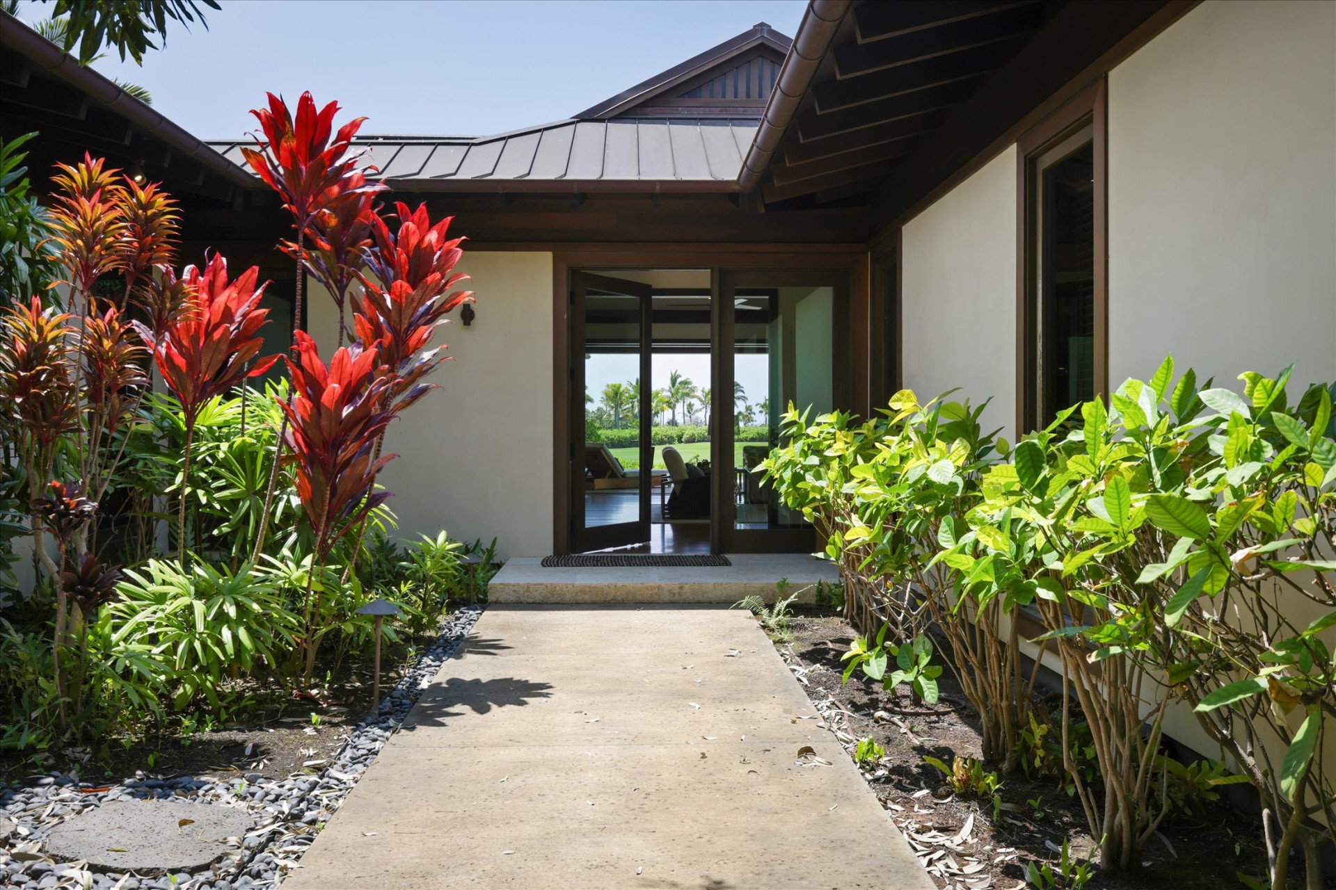 Tropical entry walkway with red ti leaves